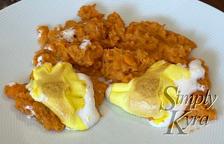 Image shows orange yams on a white plate with two brown topped yellow mounds surrounded by white. 