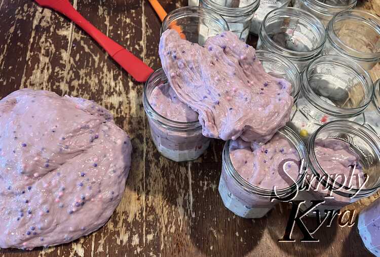 Like before some of the jars are topped up with the current purple slime with the remaining ones just with the first white layer. The excess slime is sitting to the left or pulled apart on top of the jars to highlight the small balls within the purple slime.