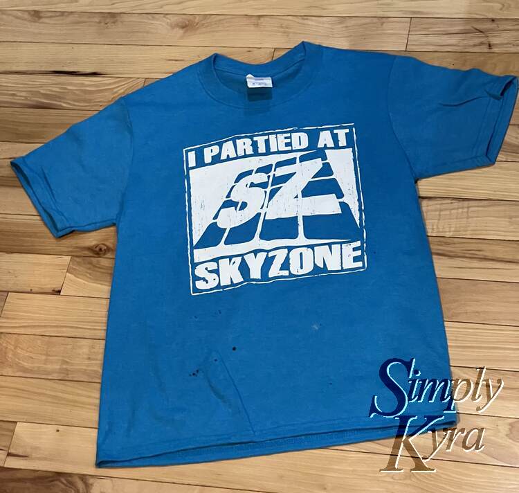 Image shows a blue shirt saying "I partied at SkyZone" and a "SZ" logo. 