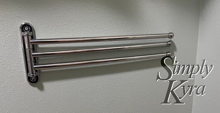 Image shows the towel holder attached to the wall with the rods laid flat.