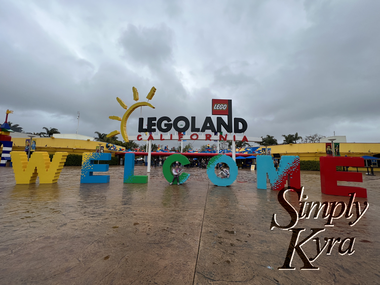 Image shows the kids posed by the Welcome sign outside the entrance.