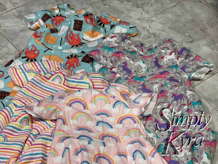 Image shows a flat lay of the front of four dresses with mostly the bodices captured in the image.
