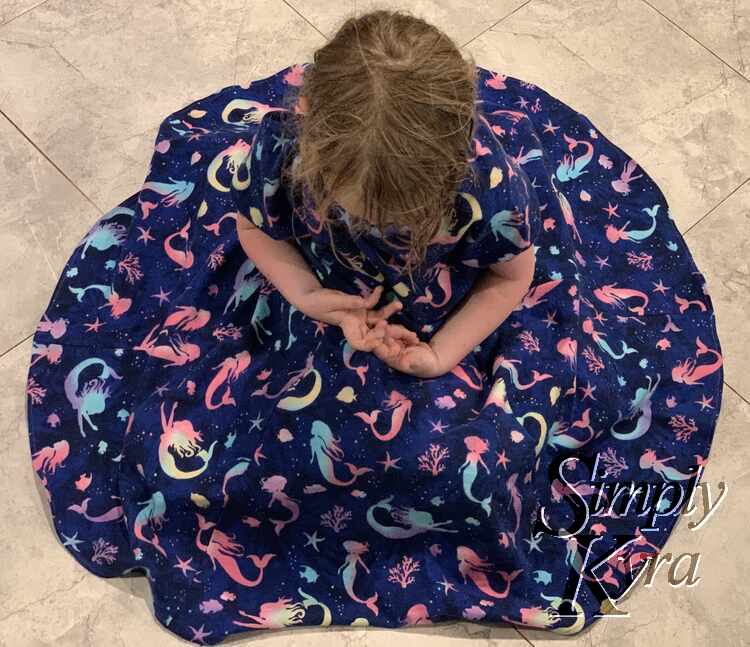 Image shows the dress being worn while seated on the floor with the skirt circled out.