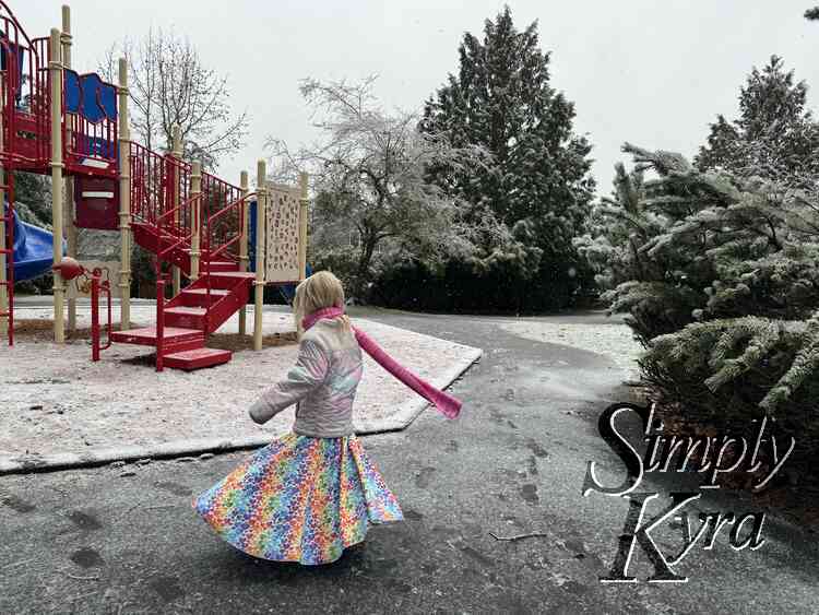 Spinning with a coat and scarf on over top in the snow.