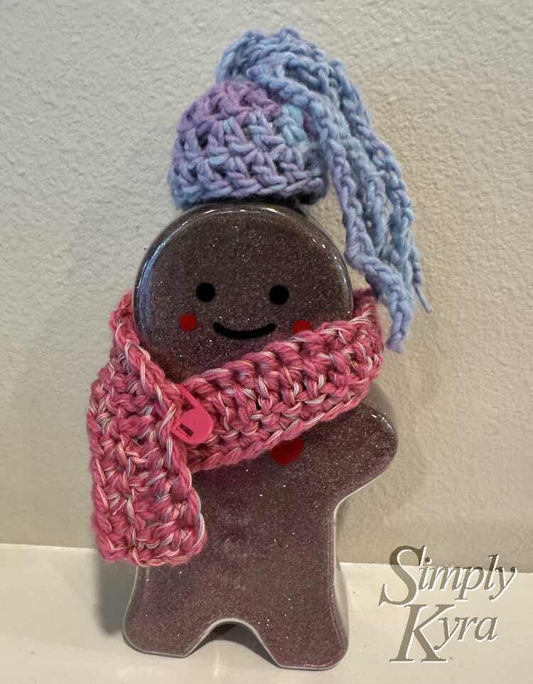 Image shows the ginger girl bottle wearing the hair and the scarf closed with a stitch marker holding it in place.