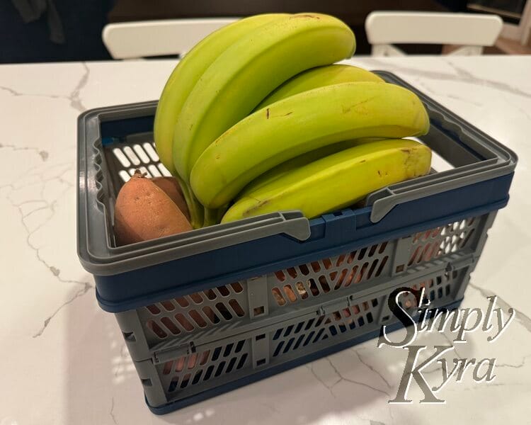 Image shows the basket set up and filled with orange sweet potatoes and bananas. 