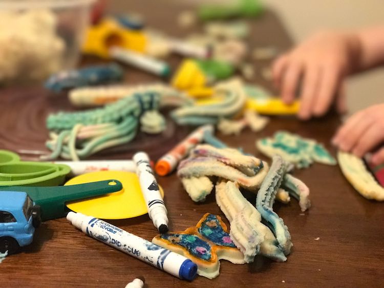 You could make your playdough look more Christmas themed with food dye or accessories. Or make plain playdough, pull out your cookie cutters, and have them use washable markers to decorate their own cookies.