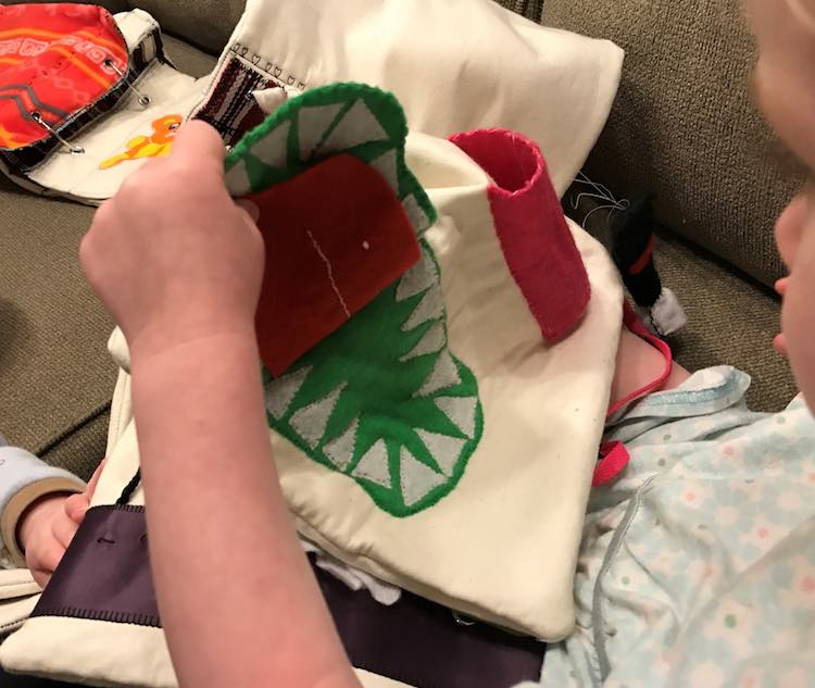 Toddler playing with her crocodile page.