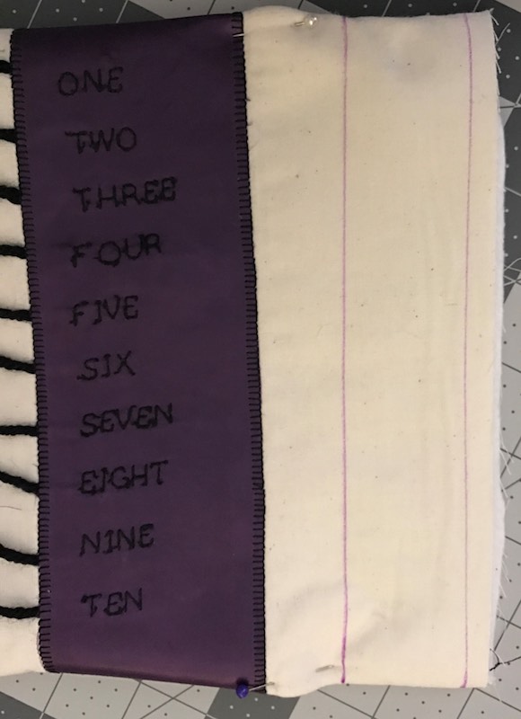 After sewing the page to it's reverse and with the rigidity of the purple fabric I added a pin near the grommet line so the page wouldn't fold in and be stuck that way.