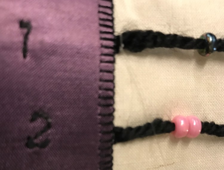 Attached a fishing line to the edge of the yarn and sewed into the page and under the purple fabric to make sure it was secure.