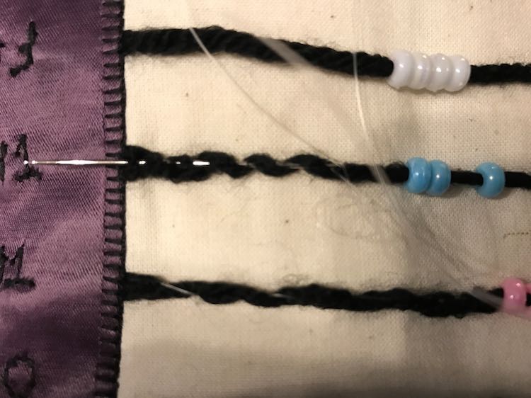 I then sewed along the yarn making sure to sew through and around it to make sure it wouldn't break. Make sure to go through the beads and confirm they're still easy to move.