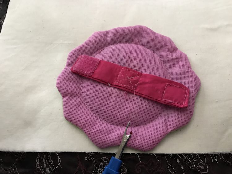 I had a plastic mirror that was part of a baby gym. I used a seam ripper to remove the strap on the back.
