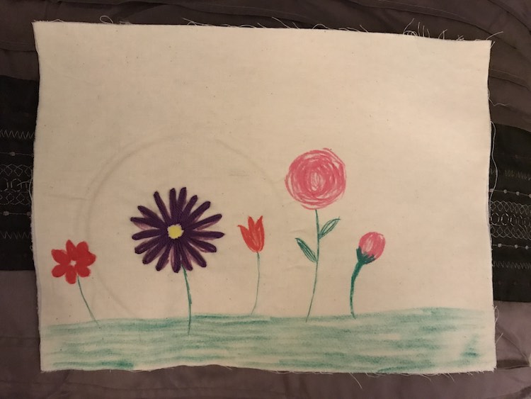 I colored in the grassy ground and a couple flowers on my quiet book page. I then used an embroidery hoop to keep the page taunt but with the interfacing it ended up leaving a mark for a couple days before it disappeared. 