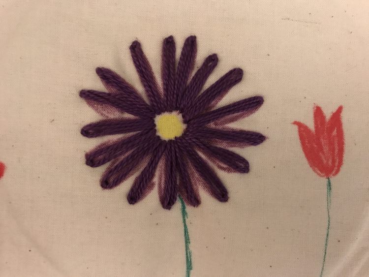 I kept this flower simple so you could see the background fabric marker colors. I kept the center of the flower empty to let the yellow shine through. I then matched the purple and used a detached chain stitch for elongated petals overtop of the purple fabric marker petals.
