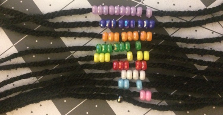 Created ten sets of yarn with a knot one either end and 1-10 beads on each. Made sure each set of beads was it's own color.