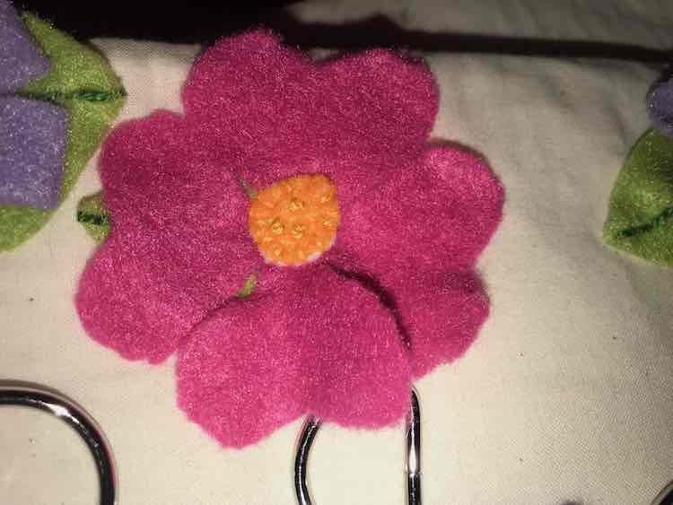 Simple heart-shaped petals on this flower. It was sewn together with simple stitches along the outside of the orange center and then decorative french knots were added.