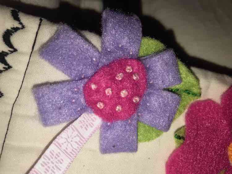 Folded over long rectangles and sewed them down. Added the center of the flower and decorated it with french knots.