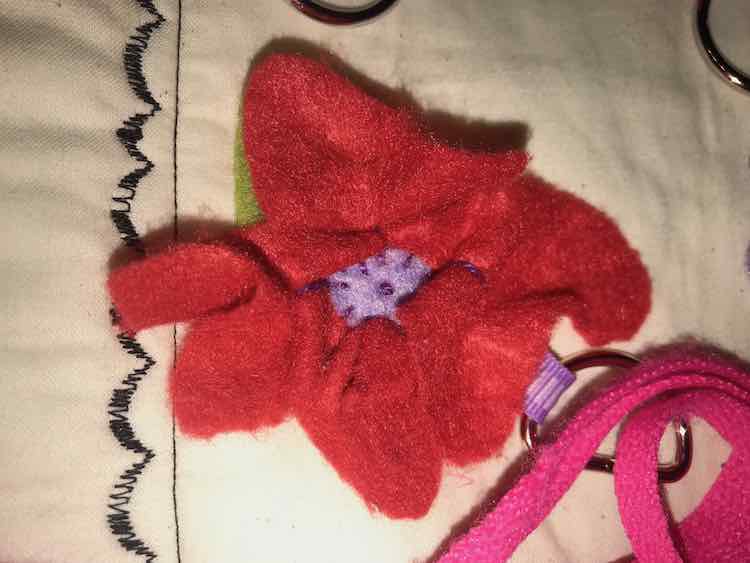 Sewed down the flower by going around the outside of the center and then added a french knot to the beginning. The petals are shaped by adding some stitches to the center of them and pulling it a bit tight.
