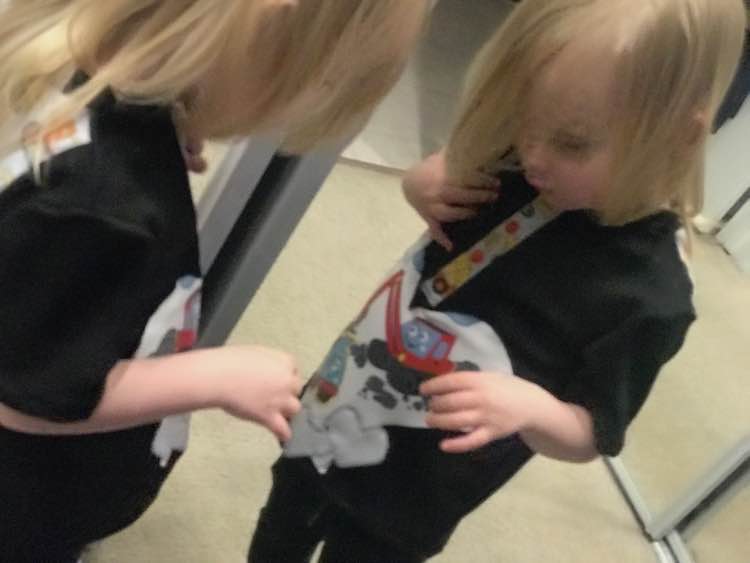 Checking her shirt out in the hallway mirror in our bedroom.