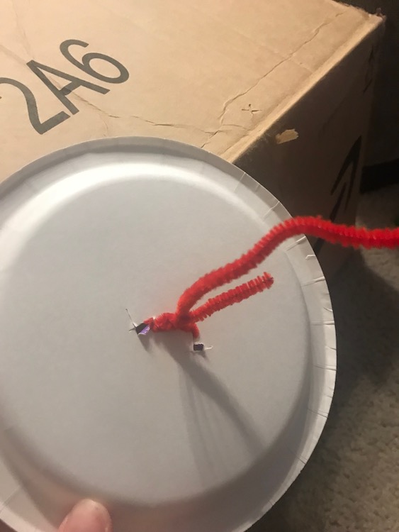 Twisted the pipe cleaner ends around each other to secure it on the wheel and add space between the wheel and box.