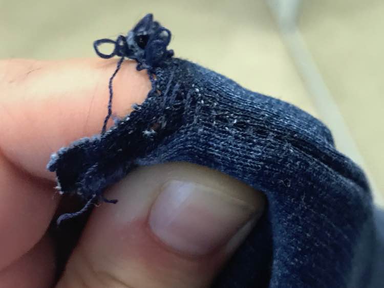 I found it easiest to put my finger directly behind the seam and then pull the fabric on either side of the seam away so the stitches are more accessible.