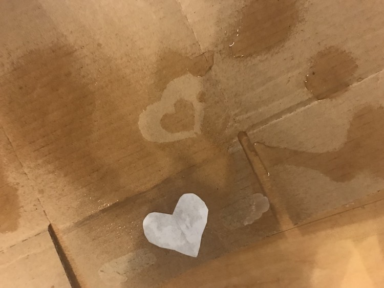 Simple cardboard with a dry heart surround by water. Dry and wet make the positive and negative impressions.