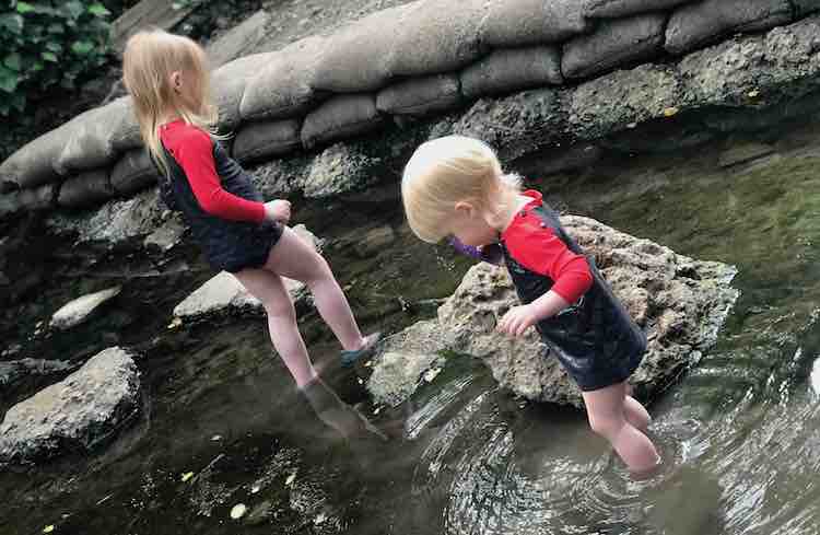 Both girls exploring a creek in their new swimming suits. 