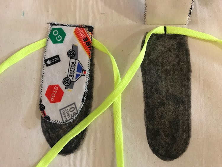 Sew the shoe lace to the center top of that black spot you colored in (right side) and then sew your tongue over top (left side). Do this on both sides.