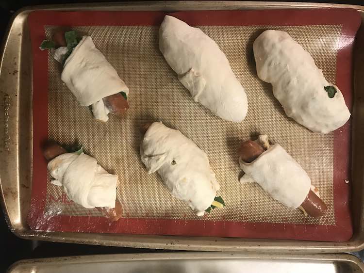 Once the sausage is wrapped place it on a cookie sheet, cover, and let rise as the oven preheats. You can also wrap the baking sheet and bake it later.