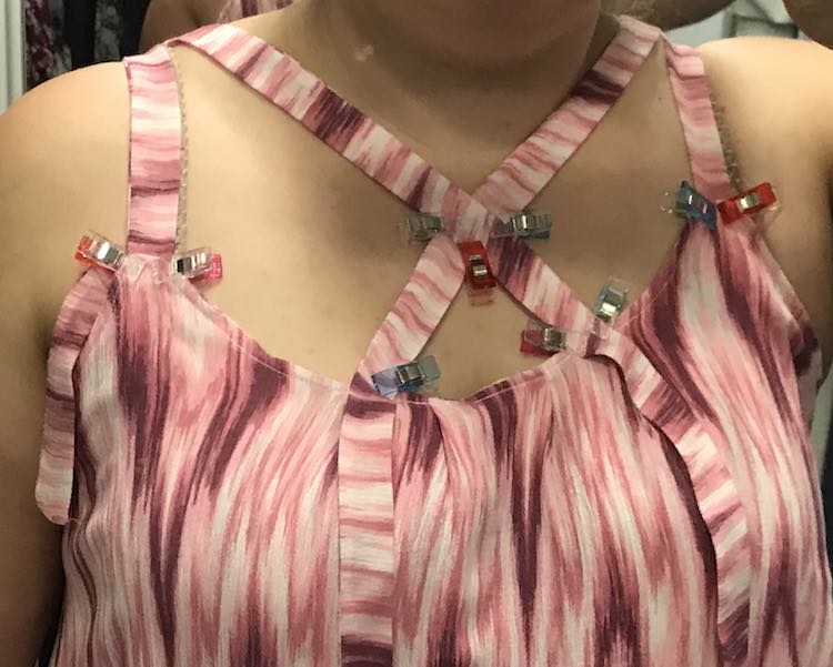 I put my shirt on backwards and pinned the straps into place. After taking it off I measured the straps from the front to the pinning and tried to equal them out so it wouldn't be crooked. You can try on again the right way to confirm.