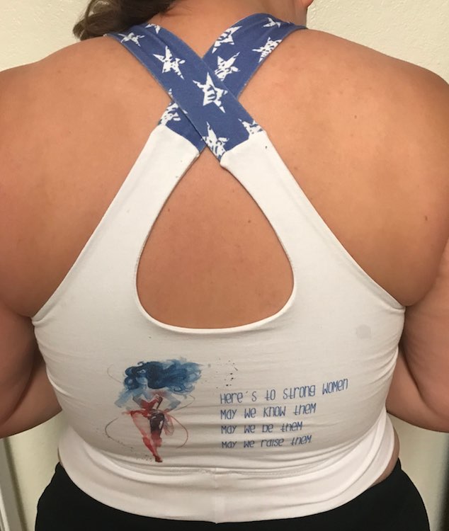 Image shows the back of my Wonder Woman bra showing Wonder Woman and a quote saying "Here's to string women / May we know them / May we be them / May we raise them". 