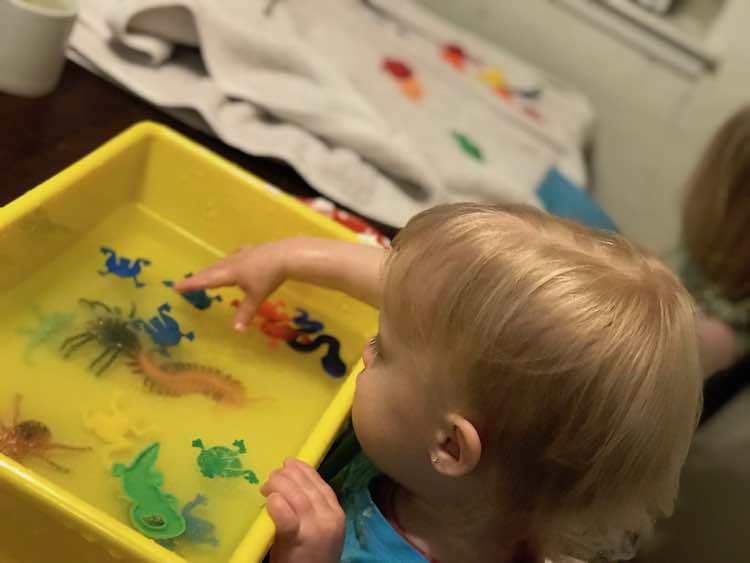 Zoey rinsing her toys as Ada dries them in the background.