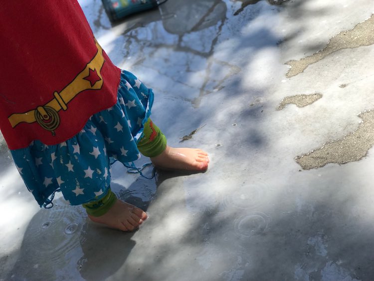 Zoey standing in the oobleck tinged water.