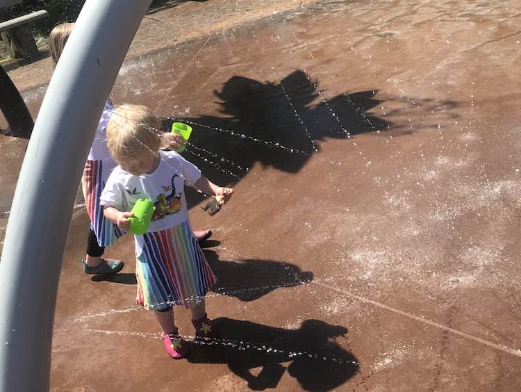 Hanging out in the water with your dinosaur, both here and above, at two separate spray parks.