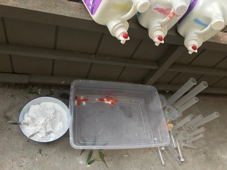 And then laid out a bin to catch the vinegar with baking soda on one side and all the plastic mixing supplies on the other side.