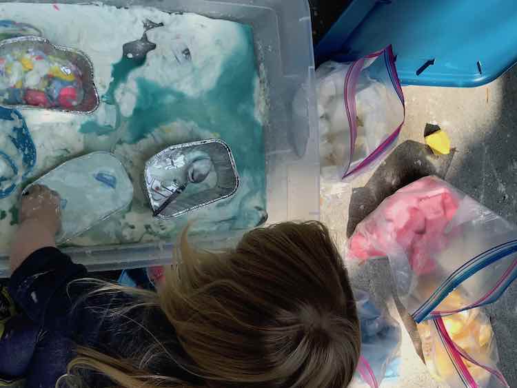 Ada playing in the vinegar and oobleck sensory bin.