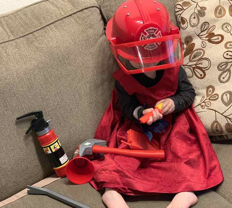 Laid out with the red dress over top of the garment and with her firetruck-related accessories to complete the look.