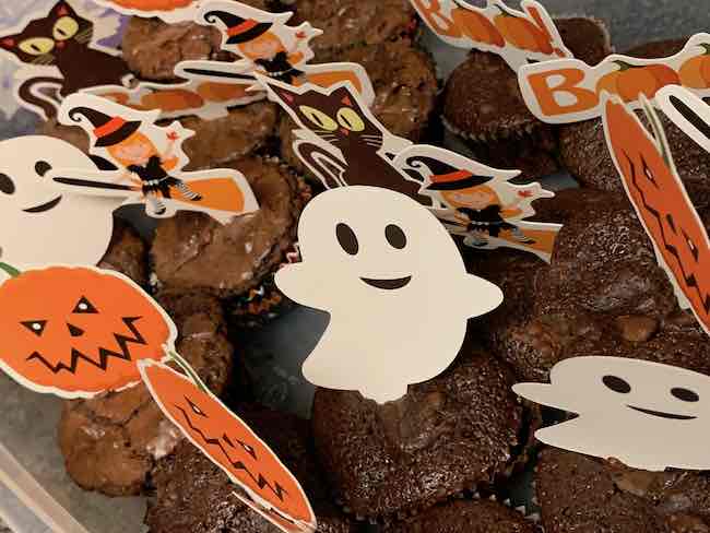 After they cooled I put most of them (that would fit) in a large plastic container and added Halloween themed cupcake toppers.