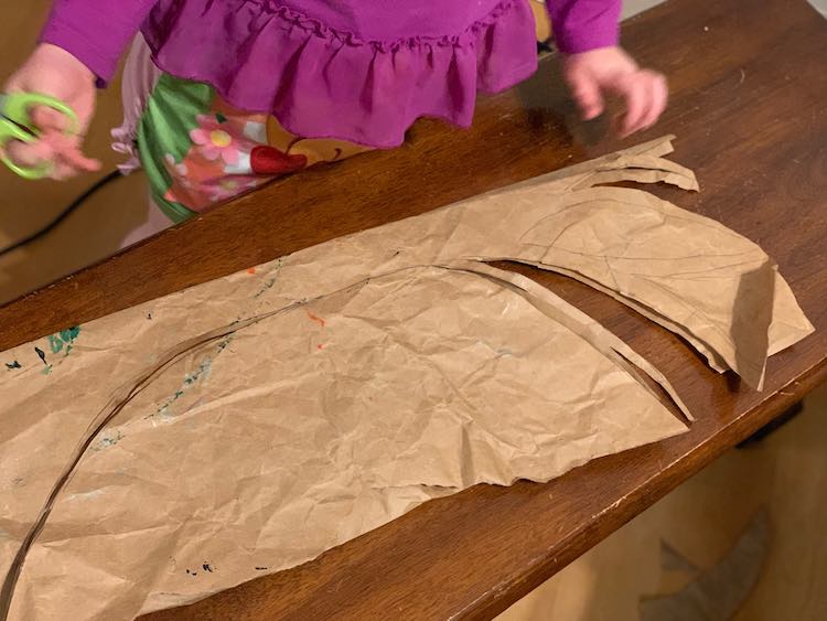 I started out by taking some brown paper, folding it in half, and quickly sketching half a tree trunk with branches on it. Make sure the tree trunk is on the side with the fold.