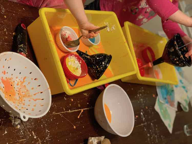 Kids with their new oobleck containers inside their main oobleck container.