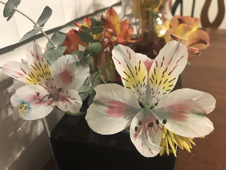 Mostly white flowers with some blue hue added from the food dye in the vase of water.