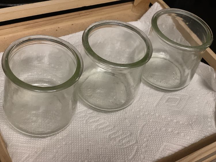 Three identical jars lined up on a paper towel lined tray.