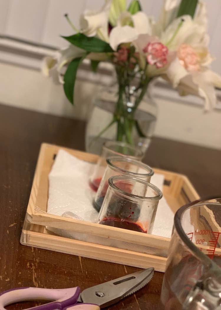 Tray with the jars of food dye laid out next to my vase of flowers, jug of water, and scissors.