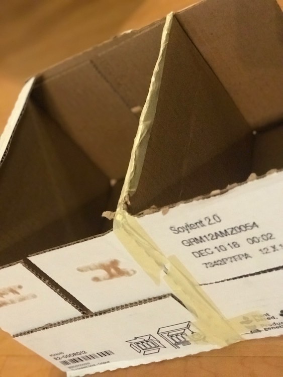 Closeup of the side of the two opened boxes. You can see the masking tape connecting the two boxes on two of the four sides. 