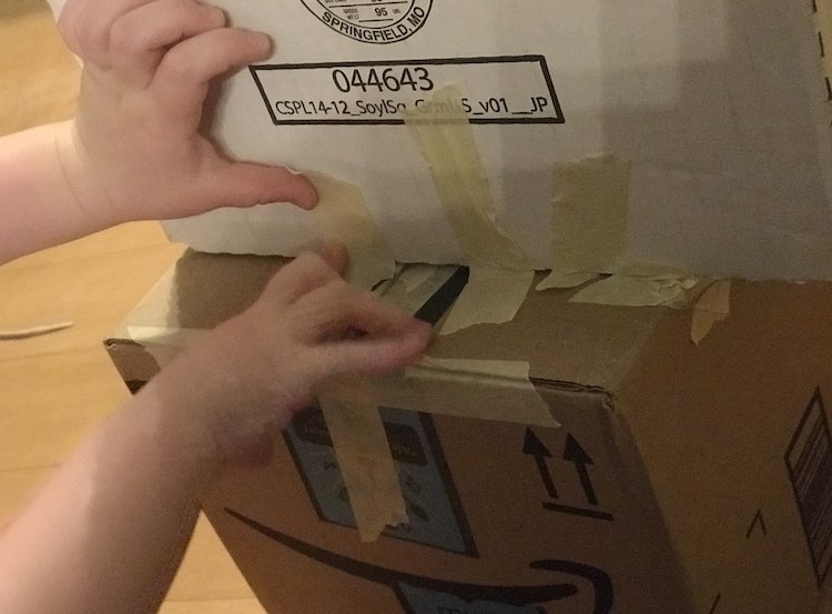 Shows Ada holding the tape onto the box. 