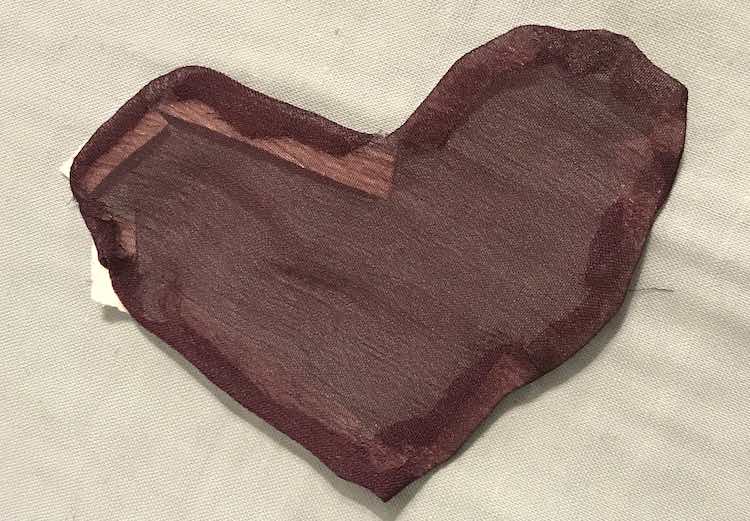 Right side of the heart shows a smoothed edge. The fabric isn't opaque so you can easily see the paper covered tape in the upper left corner along with some of the other, more transparent, tape.