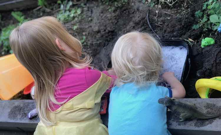 Ada and Zoey playing in their dinosaur 'bath tub'.