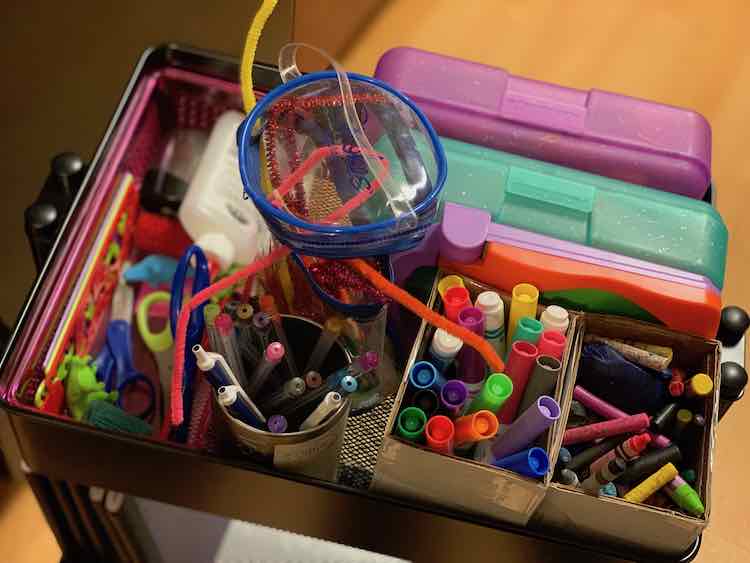 Top level of the art trolley with all the organized art supplies.