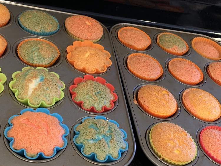Baked multi-colored angel food cake cupcakes ready and browned on top.