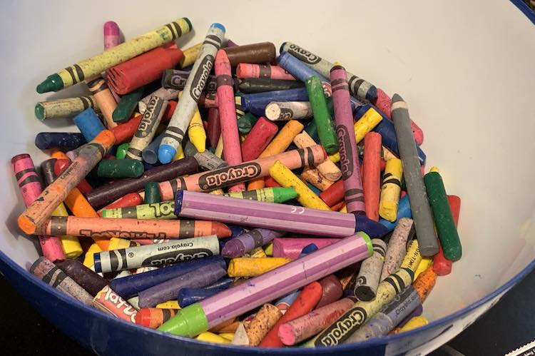 Plastic bowl half fulled all our excess crayons.
